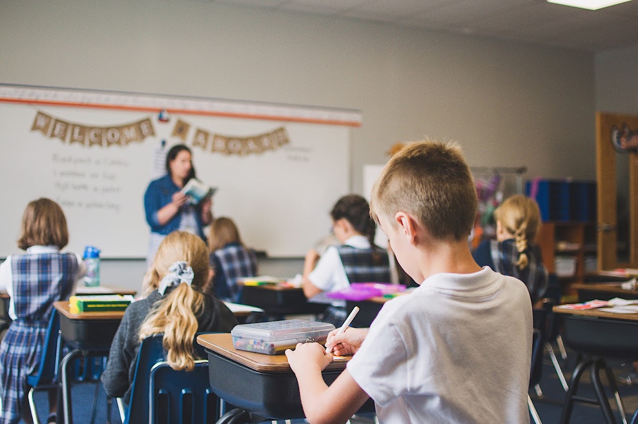 Third graders listen on the first day of school.