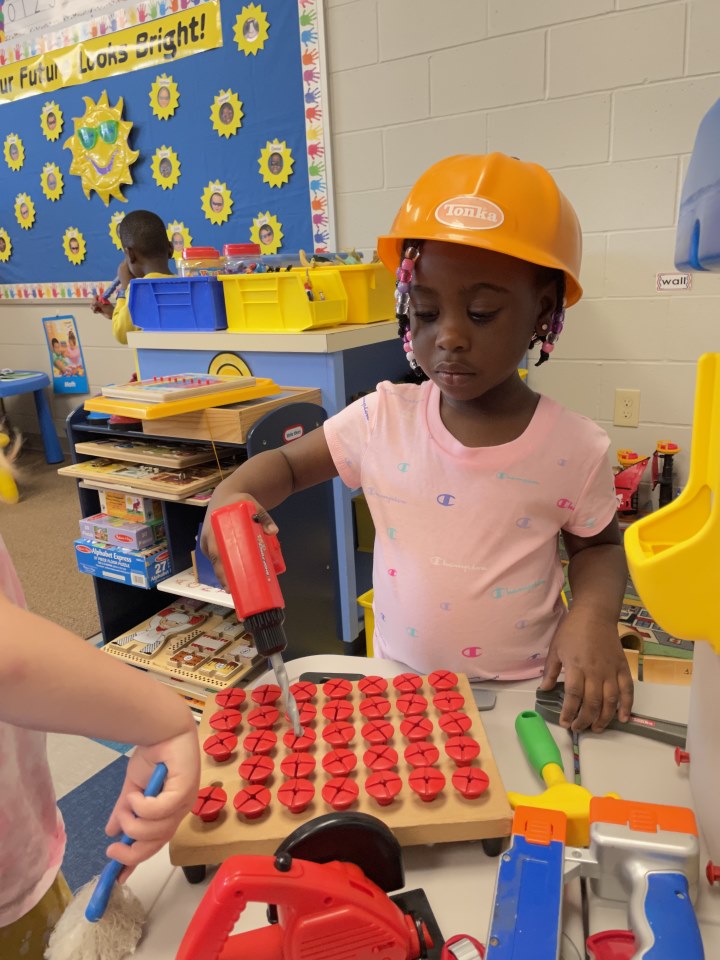 A K4 student dresses up during center time.